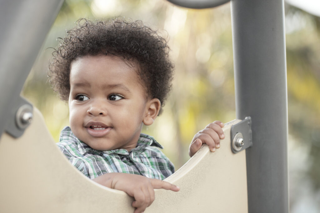 Decorative image of a toddler playing at the park