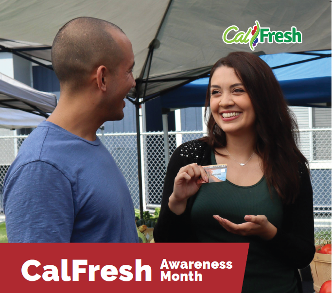 A photo of a woman showing her EBT card to a male friend.