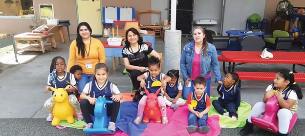 A group of preschool students pose for a photo with their teachers
