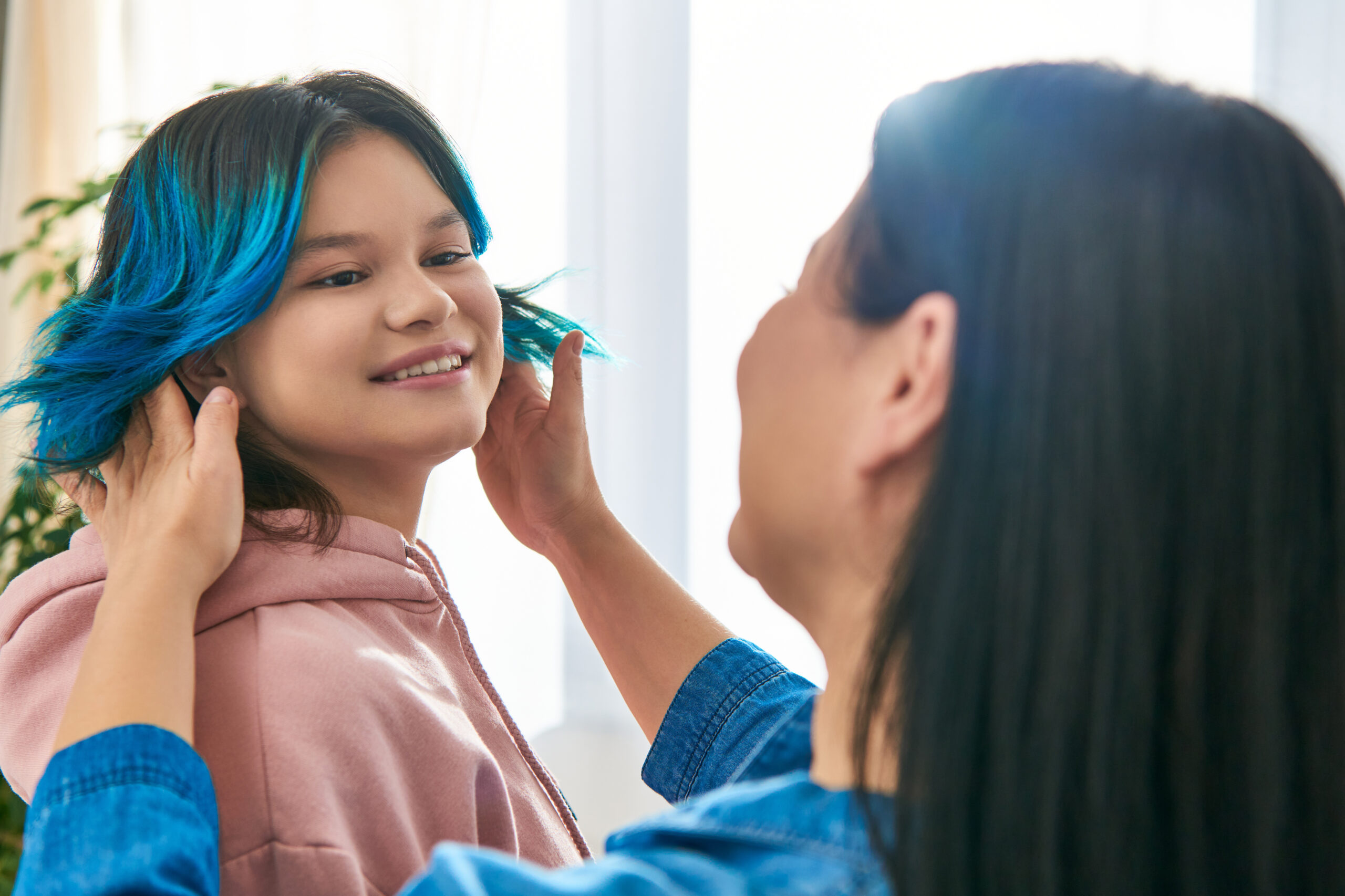 A pre-teen girl looks over her shoulder smiling at her mom or aunt.